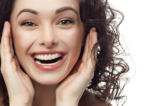 closeup portrait of attractive caucasian smiling woman brunette isolated on white studio shot lips toothy smile face hair head and shoulders looking at camera tooth